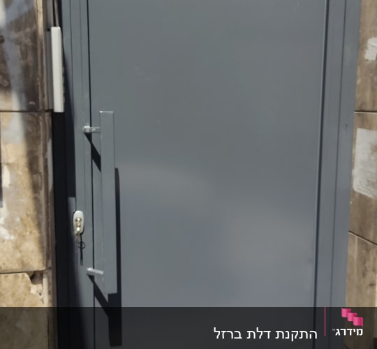 דלת מתכת אפורה עם ידית ארוכה ומנעול